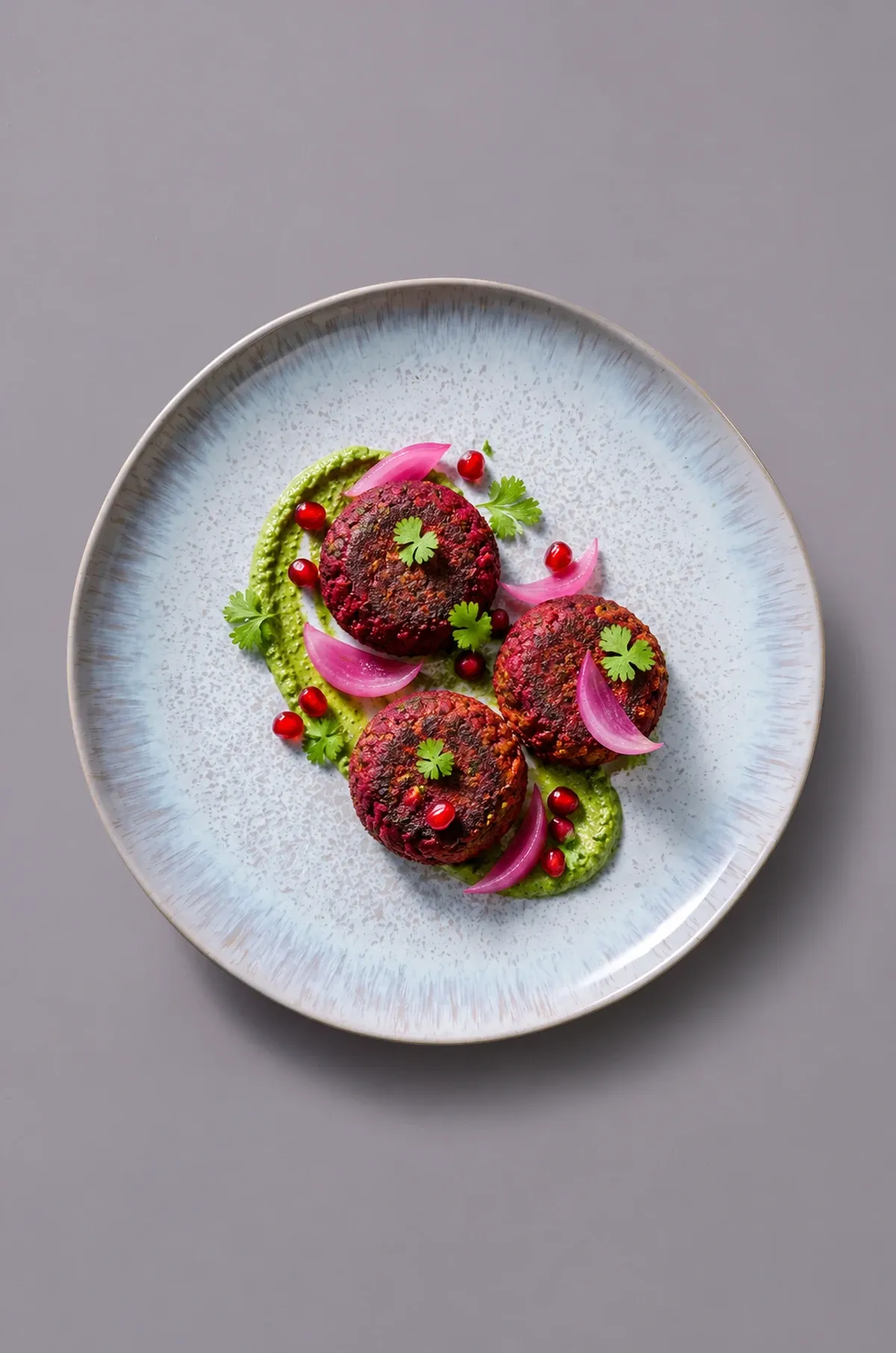 Beetroot galouti on pale grey dinnerware.