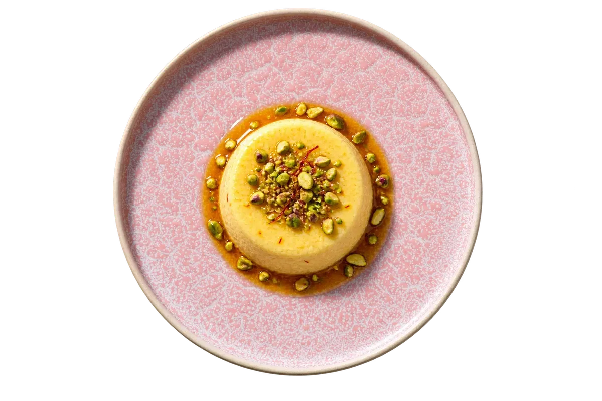 Coco Pink dinnerware serving saffron bhapa doi with pistachio and a little jaggery syrup.