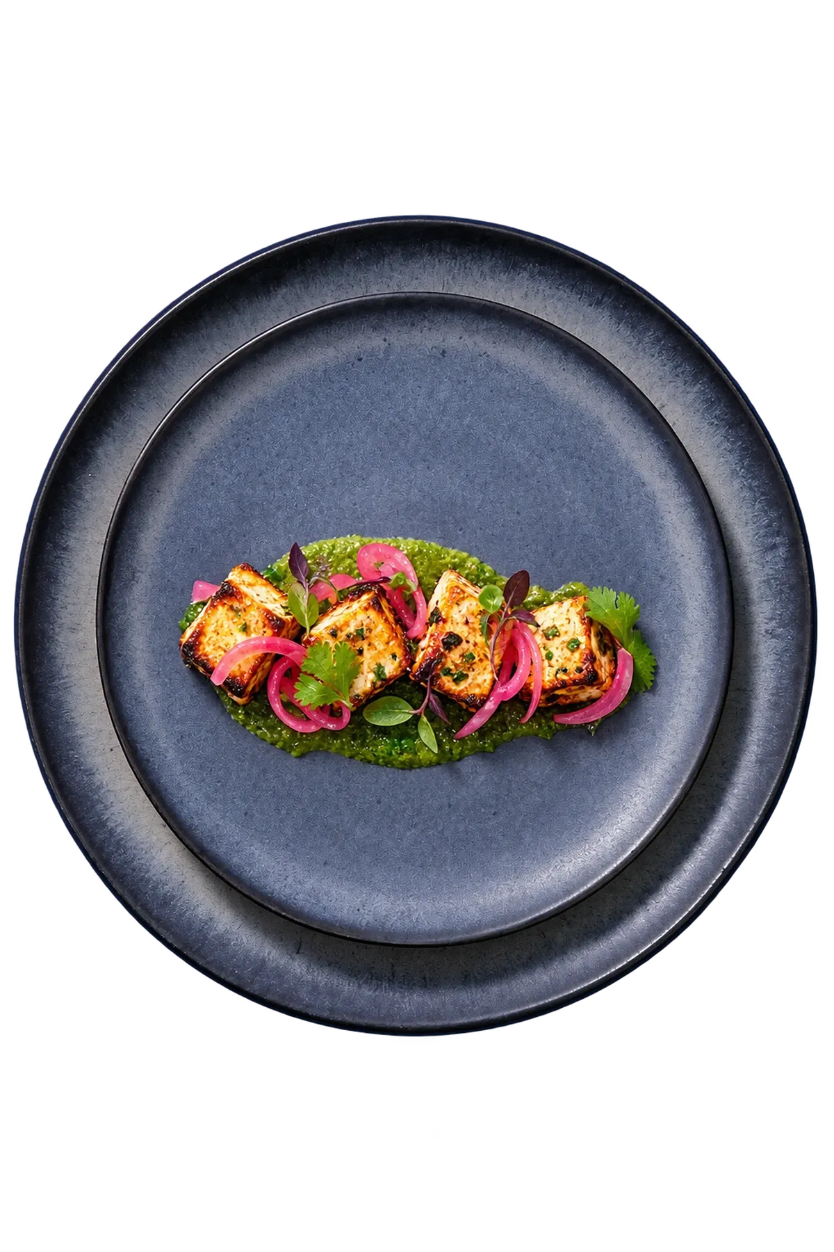 Houston dinnerware serving small paneer kebabs with coriander chutney and pickled onion.