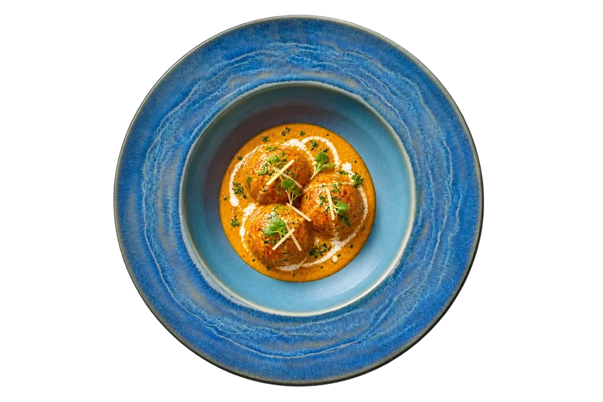 Miami dinnerware serving paneer kofta with a small pool of mild cashew gravy.